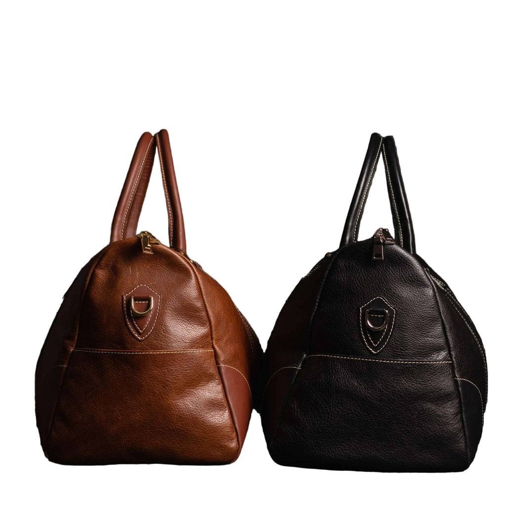 "The Shield Duffle shown in cognac and black — handcrafted full-grain leather duffle bags available in two colours, made in Canada by NAB Leather"