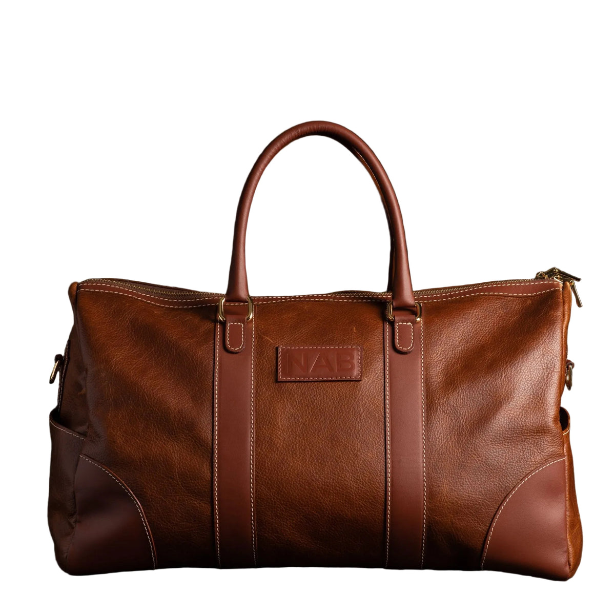 "The Shield Duffle in cognac — handcrafted full-grain leather duffle bag with rolled handles and YKK zipper, made in Canada by NAB Leather"