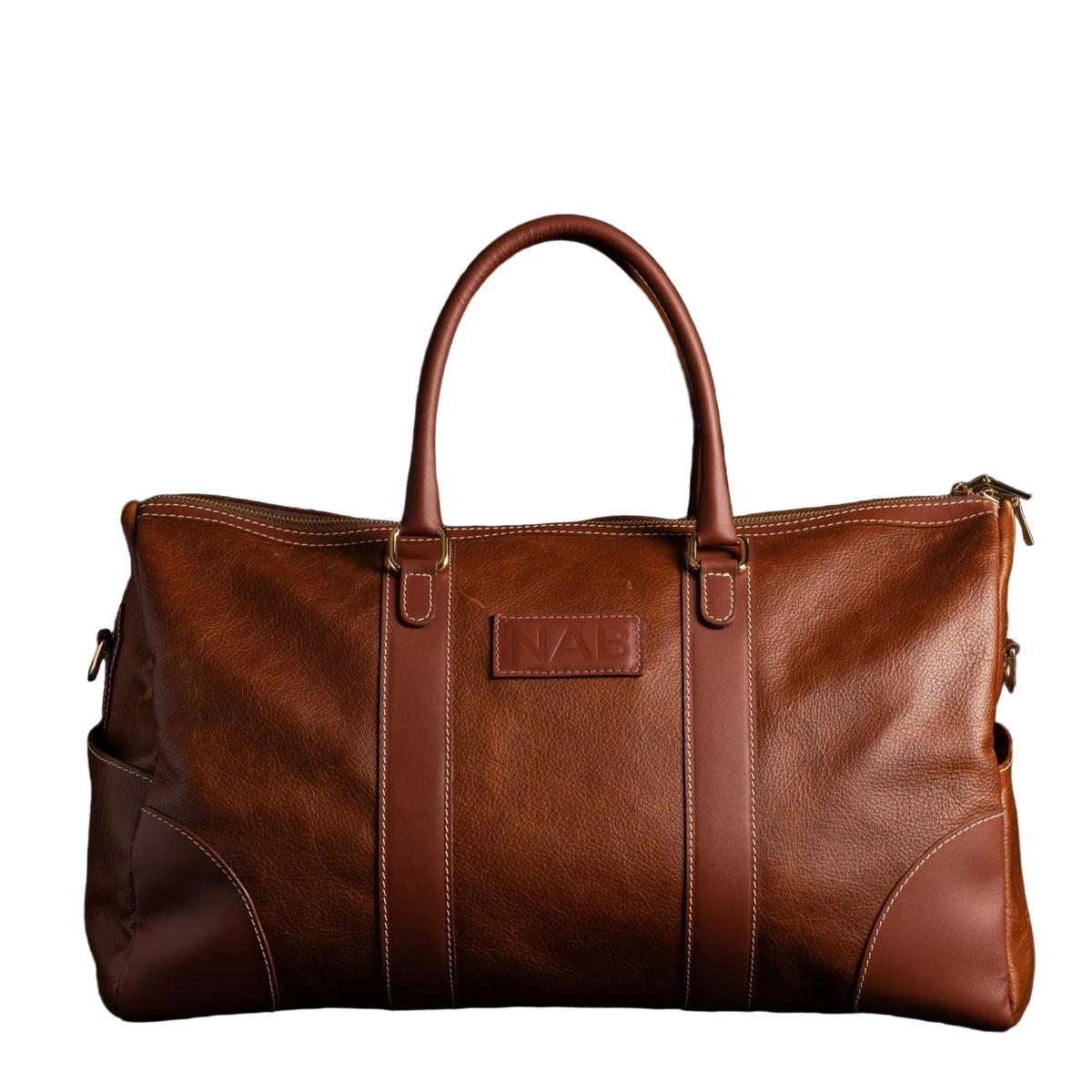 "Cognac full-grain leather duffle bag with gold hardware and rolled leather handles — The Shield Duffle by NAB Leather"