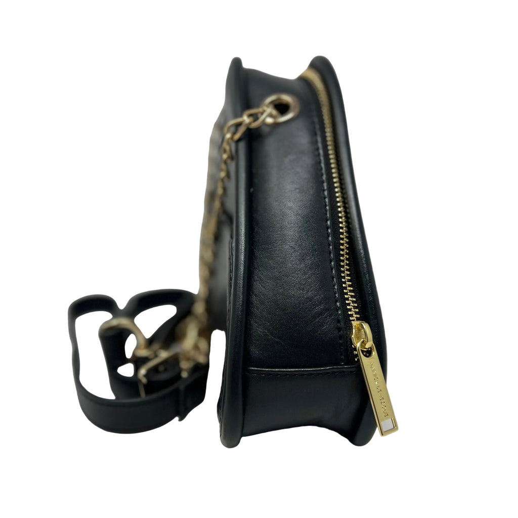Side profile view of the Kiana triangular black leather evening bag, showing its depth, a gold zipper with a logo pull tab, gold chain hardware, and a detached black leather strap in the background.