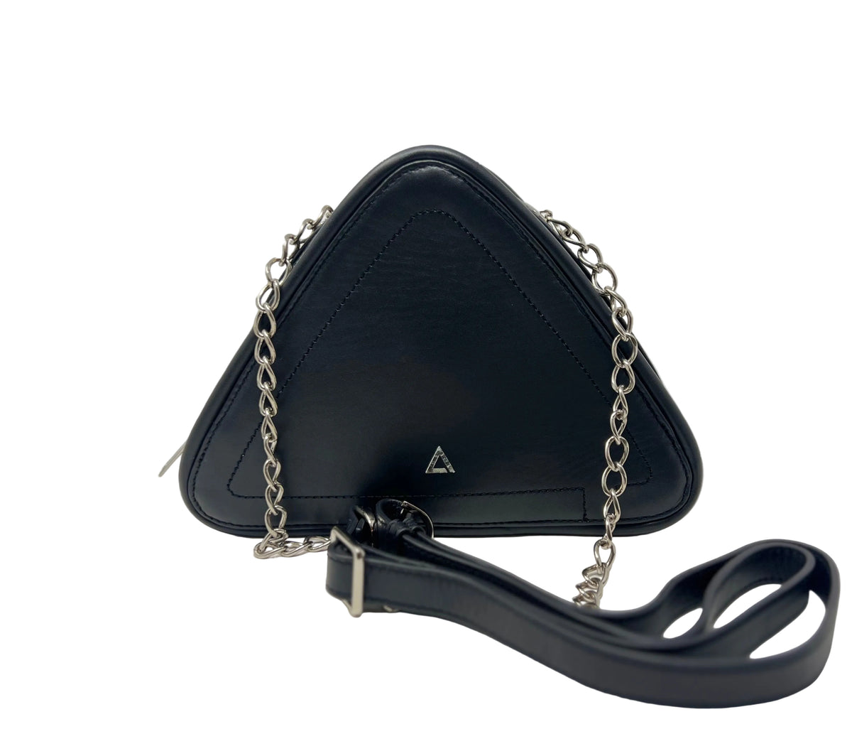 Front view of the Annick Levesque Kiana triangular black leather evening bag with a silver chain strap, silver triangle logo, and a black leather shoulder strap lying in front against a white background.