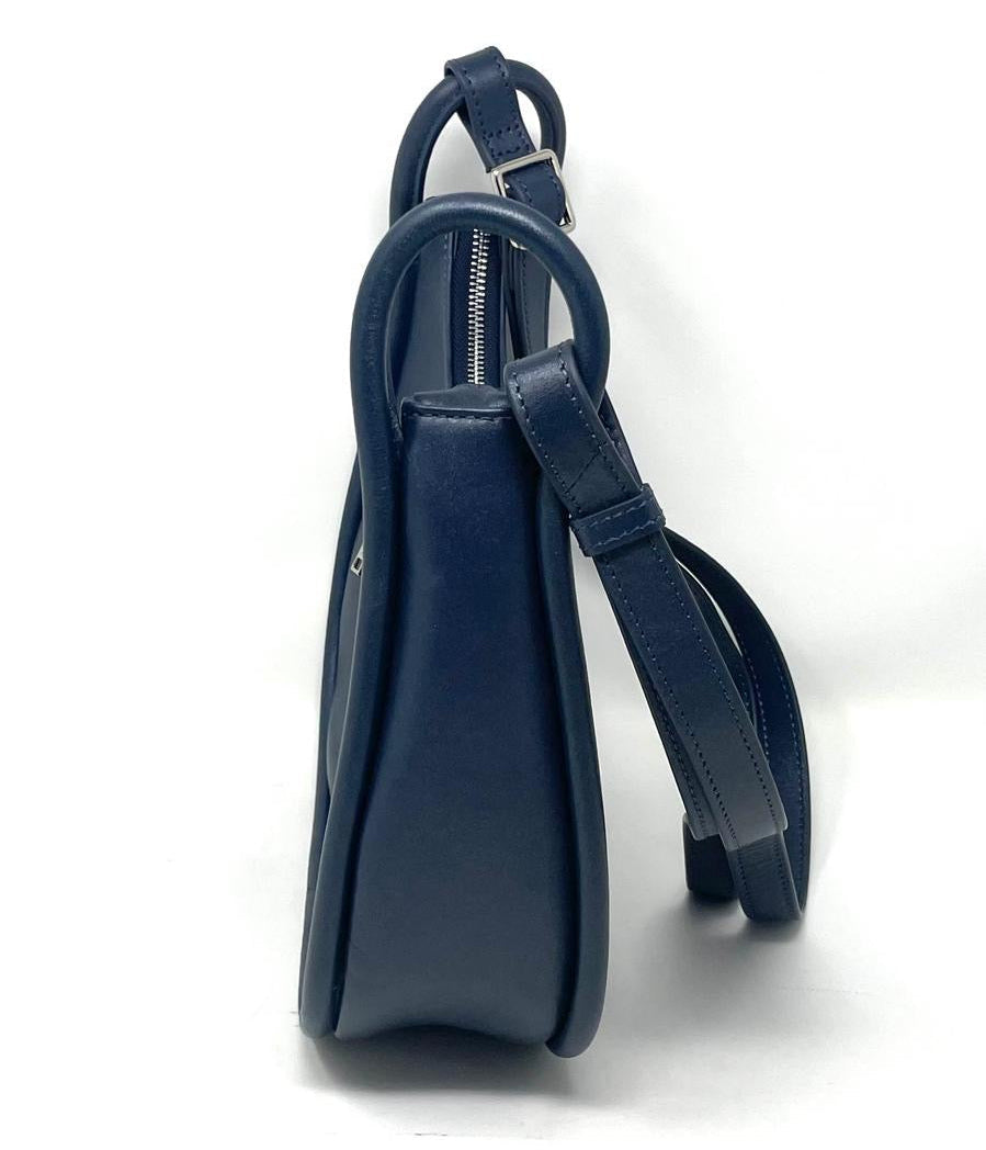 Side profile view of the Sabrina navy blue leather crossbody bag showing its slim, structured width.