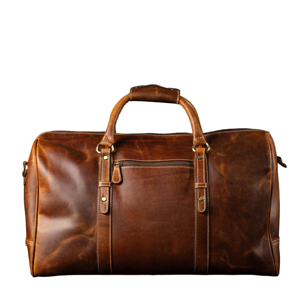 "The Wayfarer Bag — Cognac full-grain leather duffle bag with brass hardware and adjustable shoulder strap, handcrafted in Canada by NAB Leather"