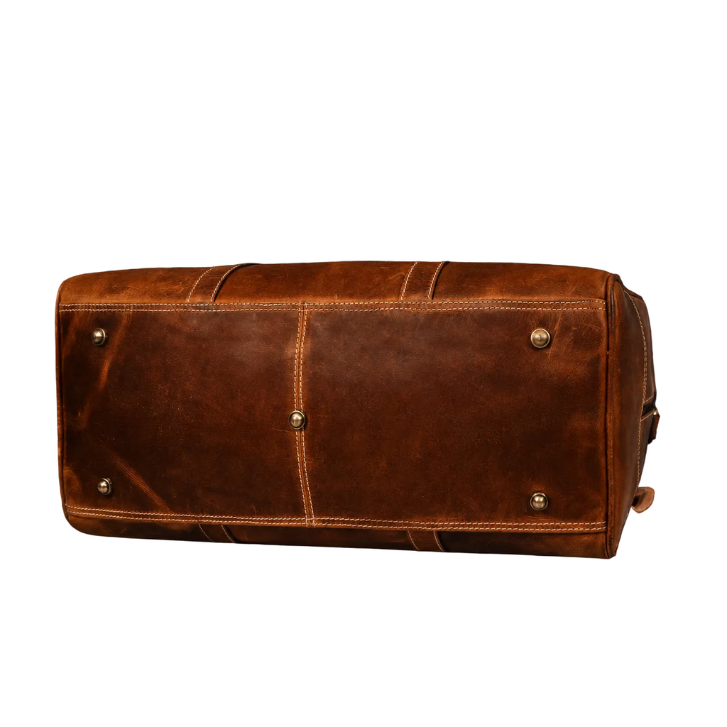 "Bottom view of The Wayfarer Bag showing structured base and full-grain leather texture — cognac leather duffle handcrafted in Canada by NAB Leather"