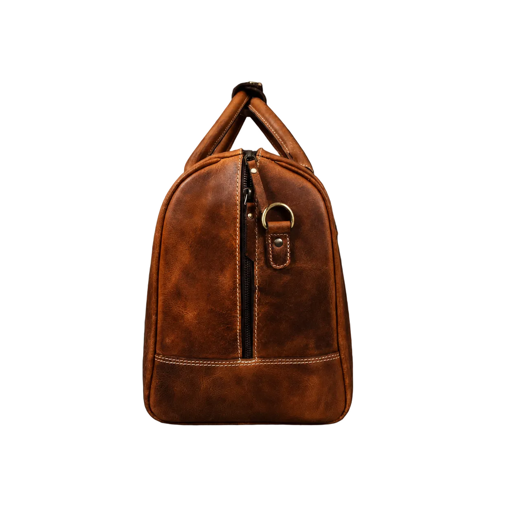 "Side view of The Wayfarer Bag showing back zipper pocket and shoulder strap attachment — cognac full-grain leather duffle by NAB Leather"