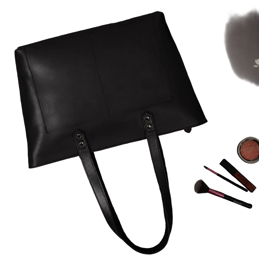 "Classic Black Leather Tote Bag styled with everyday beauty essentials — spacious full-grain leather handbag perfect for work and daily use by NAB Leather"