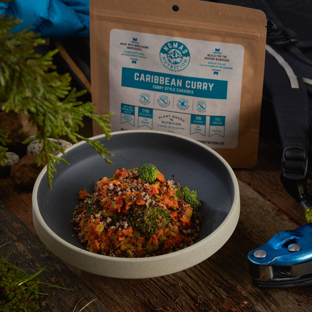 Bowl of food with a package labeled 'Caribbean Curry' on a wooden surface.