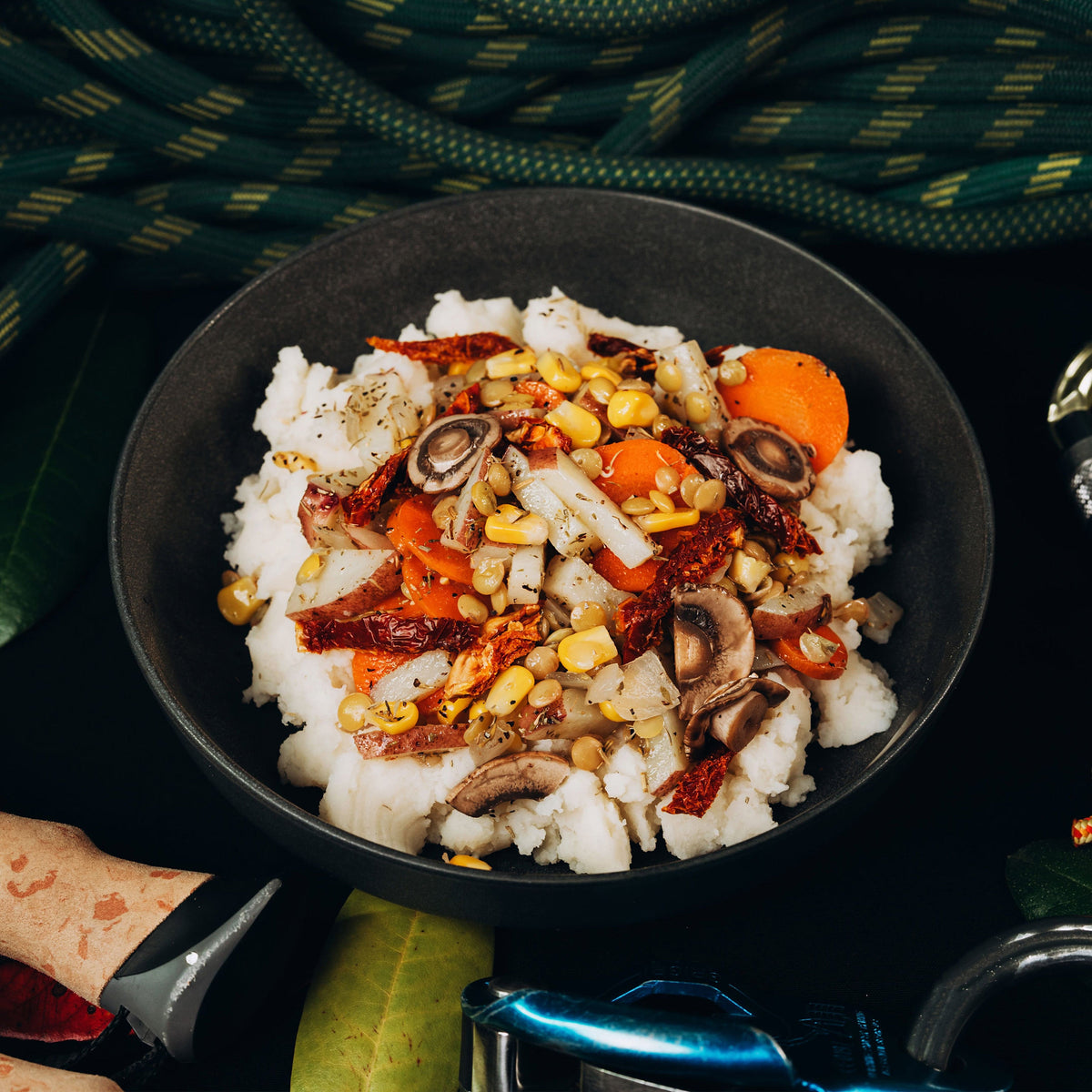 Black bowl with rice and various vegetables on a dark background